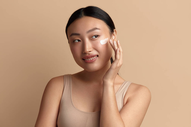 Positive Woman Applying Face Cream. Closeup Of Female Model With Fresh Skin Applying Cosmetic Product Under Eyes. Skincare Concept. High Resolution  - Foto, Imagem