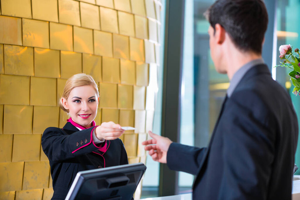 "Hotel receptionist check in man giving key card" - Zdjęcie, obraz