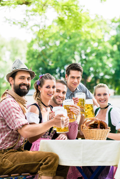 Друзів у баварський пивний сад пити влітку - Фото, зображення