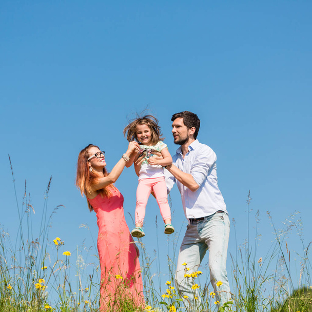 gelukkig familie met meisje en blauwe hemel - Foto, afbeelding