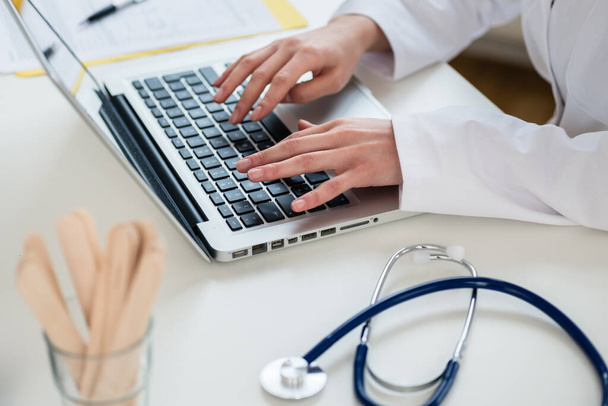 "Zbliżenie rąk lekarza piszącego na laptopie w trybie wyłączenia" - Zdjęcie, obraz