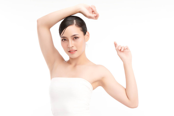 Hermosa mujer asiática joven levantando las manos para mostrar las axilas limpias e higiénicas o axilas sobre fondo blanco, limpieza suave de axilas y concepto de protección - Foto, Imagen