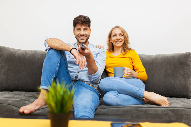 "couple watching tv in living room" - Foto, afbeelding