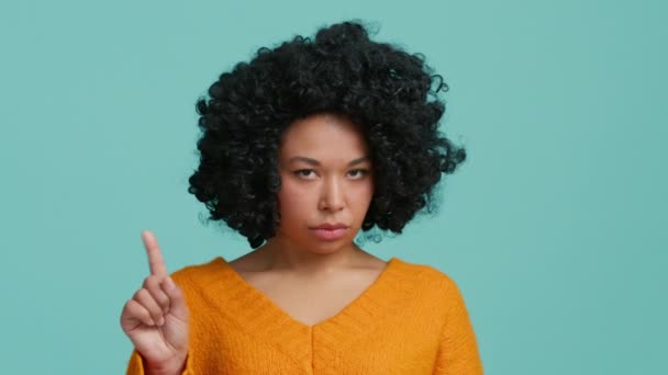 非常に深刻なアフリカ系アメリカ人の頭を振ると非常に眉を豊かに見て。否定的な答えを示す否定的な女性の手を振っ青のスタジオの背景。人差し指でジェスチャーなし - 映像、動画
