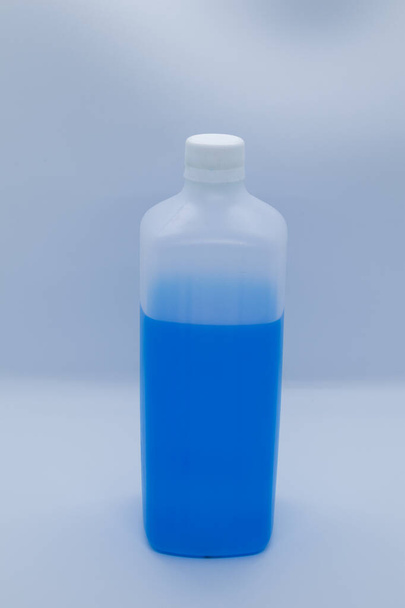 Bouteille en plastique avec liquide bleu sur fond blanc - Photo, image