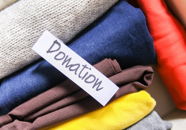"Clothes sorting in wardrobe for donation with paper note." - Zdjęcie, obraz