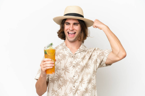 Giovane bell'uomo che tiene un cocktail isolato su sfondo bianco che celebra una vittoria - Foto, immagini
