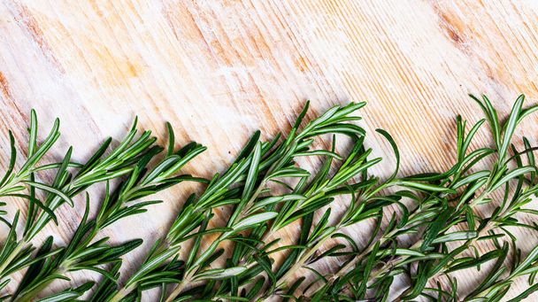 Image of green rosemary on wooden background, top view - Foto, afbeelding