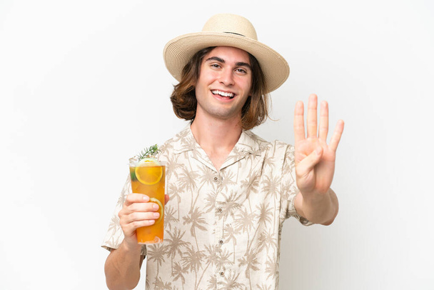 Joven hombre guapo sosteniendo un cóctel aislado sobre fondo blanco feliz y contando cuatro con los dedos - Foto, imagen