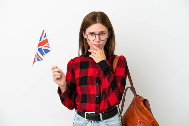 Młoda kobieta z flagą Zjednoczonego Królestwa odizolowana na niebieskim tle myśli - Zdjęcie, obraz