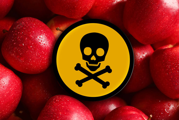 Skull and crossbones sign on fresh apples, closeup. Be careful - toxic - Photo, Image