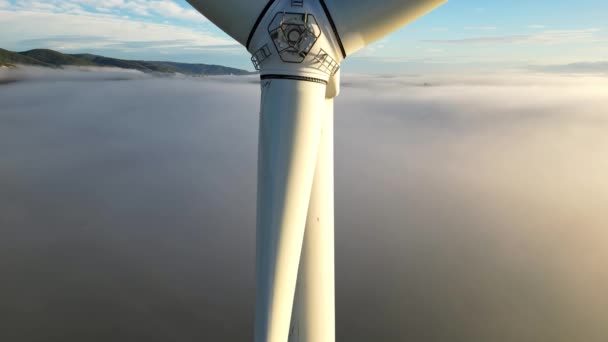 A drón szélturbinát lőtt napkeltekor sűrű reggeli köd. Szélerőművek közelről. Tiszta zöld energiát előállító szélmalmok. - Felvétel, videó