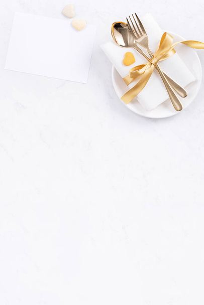День святого Валентина, День матери, праздничная трапеза, концепция банкетного дизайна - Белая тарелка и золотая лента на мраморном фоне, вид сверху, плоский уголок. - Фото, изображение