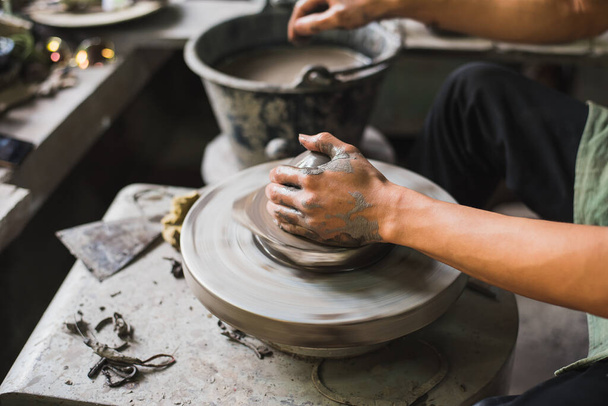 Руки гончара крупным планом формируют мягкую глину, чтобы сделать глиняный горшок
 - Фото, изображение