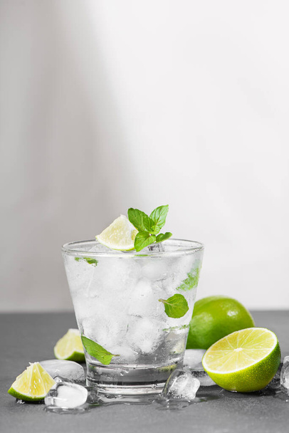 Mojito cocktail with lime and mint in glass on a grey stone background - Foto, imagen