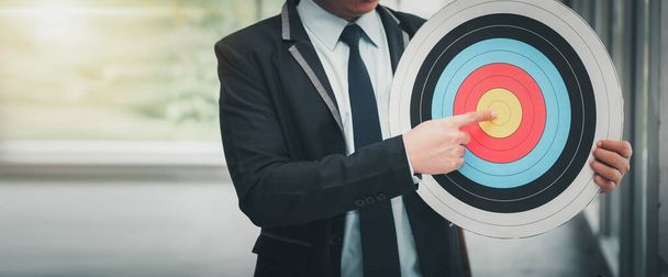 "Geschäftsmann ist Pointing Goal Target on Dartboard, Businessman Leadership Point to Strategic Marketing on Dartboard Bullseye auf seine Teamarbeit ausgerichtet. Kreative Idee für eine Strategie zur Projektdurchführung" - Foto, Bild