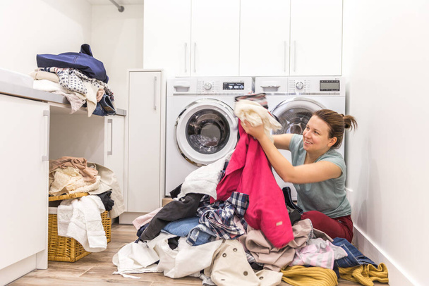 "Happy woman in a moder laundry room" - Zdjęcie, obraz