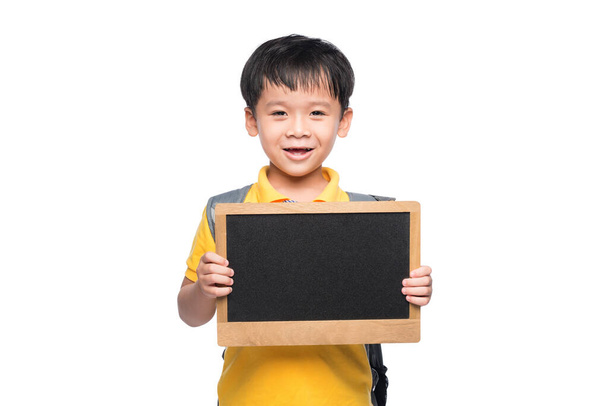 Νεαρό ασιατικό χαμόγελο αγόρι κρατώντας πίνακα πάνω από το λευκό - Φωτογραφία, εικόνα