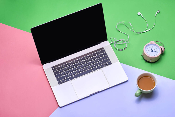"Таблиця столів з ноутбуком, чашкою кави, навушниками та камерою на кольоровому столі
" - Фото, зображення
