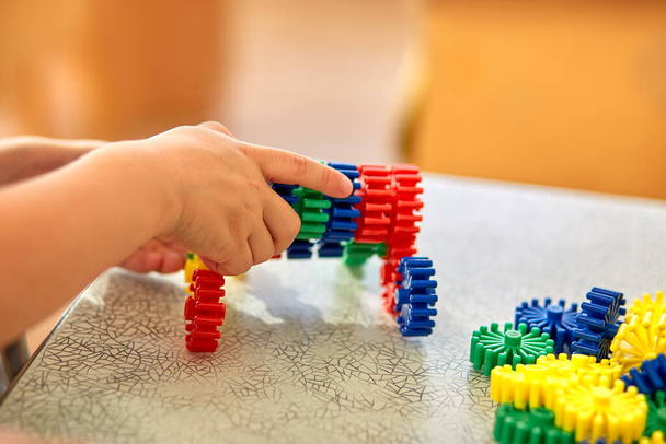 "Egy fiú egy puha puzzle-t gyűjt az asztalnál. Óvodáskorú gyermekek és oktatási játékok" - Fotó, kép