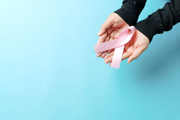 "pink badge ribbon on woman hand to support breast cancer cause. breast cancer awareness concept" - 写真・画像