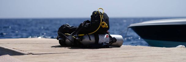 Diving equipment lying on wooden bridge in sea. Extreme sports concept - Photo, Image