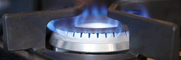 Palnik gazowy na kuchence z niebieskim ogniem przy zamknięciu domu. Koncepcja regulacji cen gazu - Zdjęcie, obraz
