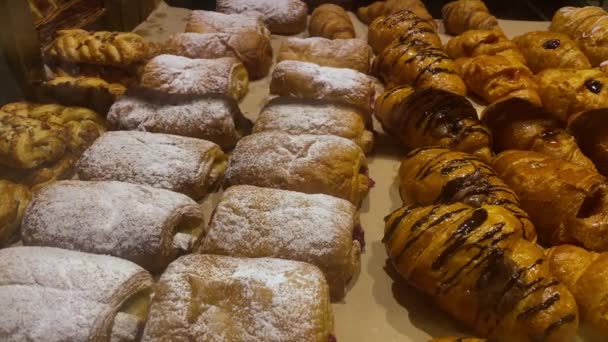 Friss zsemle és croissant a bolt előtt. Kézzel készített sütemények. zsemle és croissant kirakatban - Felvétel, videó