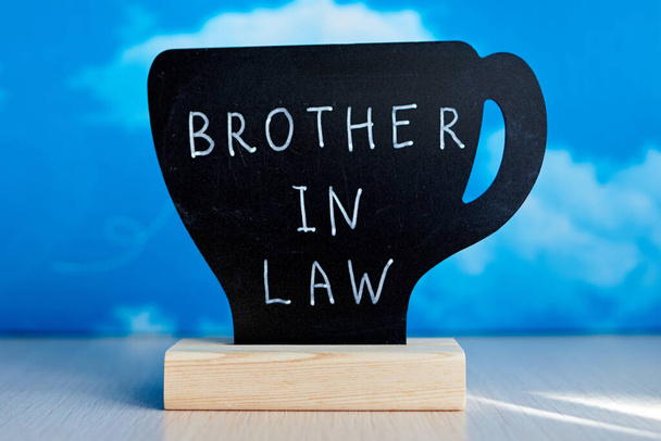 ホワイトチョークマーカーによって書かれた英語の単語"法律の兄弟"が付いているチョークテーブルのテント. - 写真・画像
