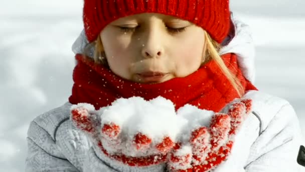 Girl blows snow from hands - Felvétel, videó
