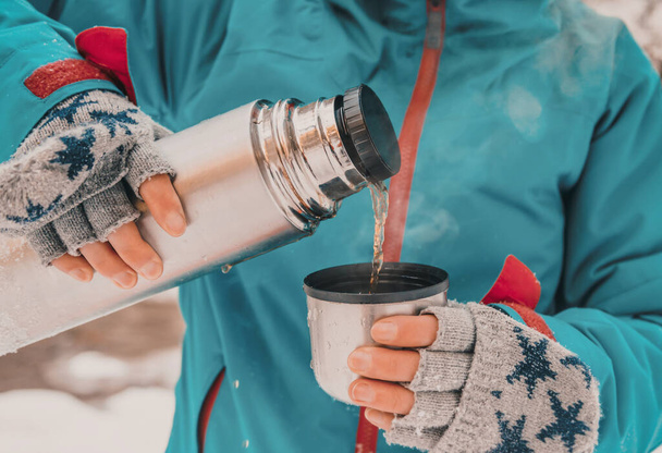 Touristin gießt Tee aus Thermoskanne  - Foto, Bild