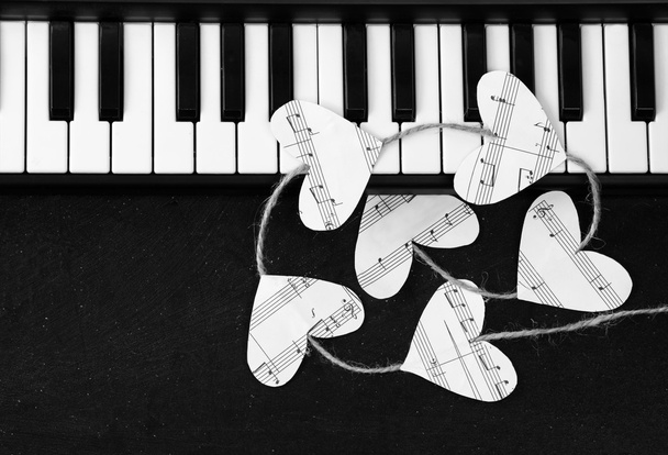 Teclas de piano e corações da música em um fundo preto
 - Foto, Imagem