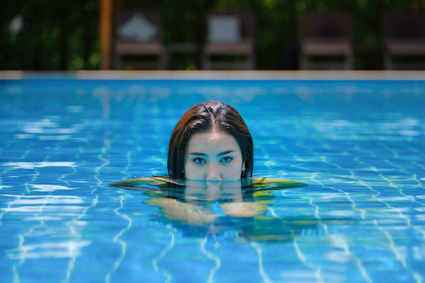 Kaunis nuori aasialainen nainen uima-altaassa rentouttava - Valokuva, kuva