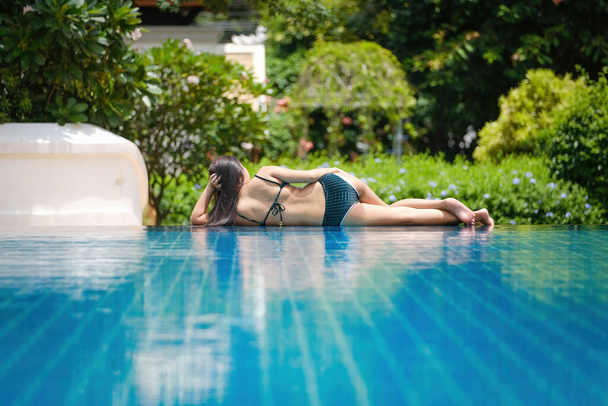 Όμορφη νεαρή Ασιάτισσα στην πισίνα χαλαρώνοντας - Φωτογραφία, εικόνα