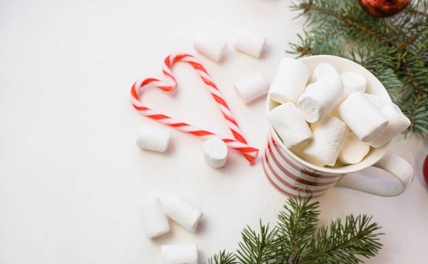 "Traditional hot chocolate with marshmallows and lollipops on a white textured background. Christmas drink theme." - Foto, Bild
