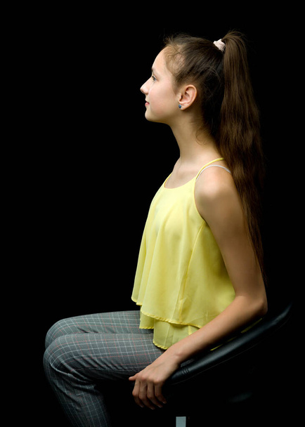 Nastoletni Dziewczyna siedzi na skórzany fotel. - Zdjęcie, obraz
