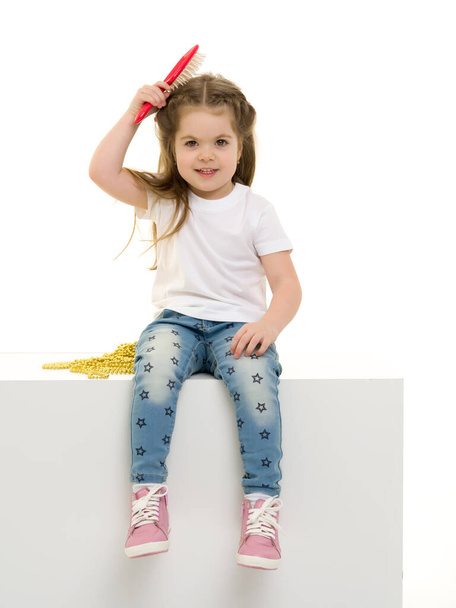 Una niña peinándose el pelo  - Foto, Imagen