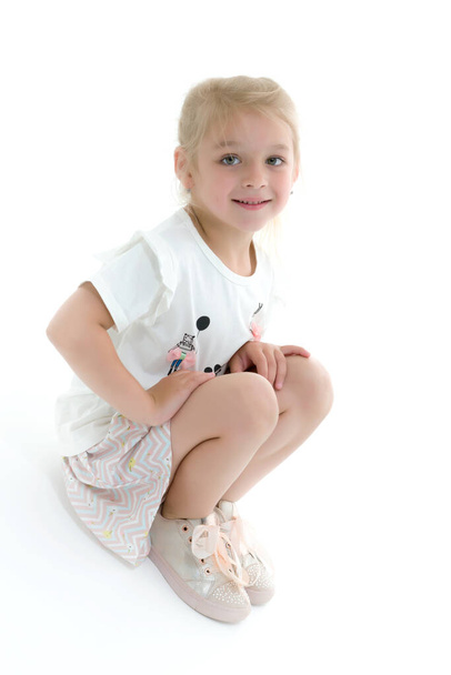 A little girl is photographed in the studio on a cyclorame. - Foto, Bild