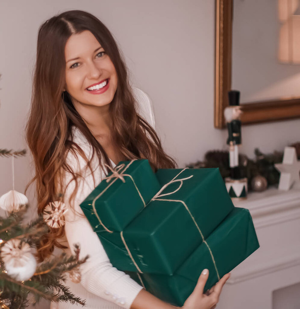 "Vacaciones de Navidad y concepto de regalos sostenibles. Feliz mujer sonriente sosteniendo regalos envueltos con papel de embalaje verde ecológico" - Foto, imagen