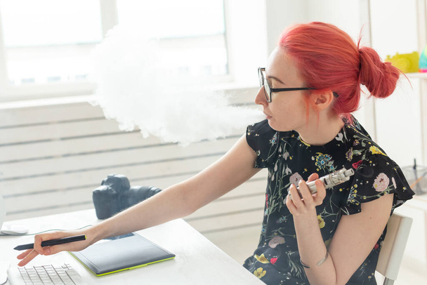 Creativo, diseñador gráfico, concepto de personas - mujer creativa joven fumar un vapor mientras trabaja con la tableta gráfica - Foto, Imagen