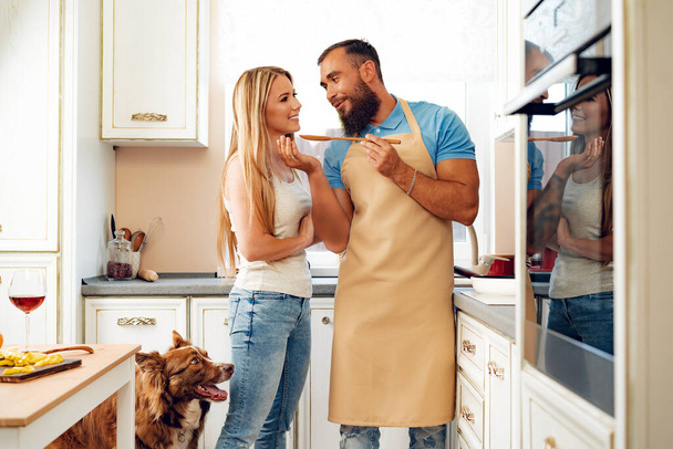 "Молодая любящая пара готовит вместе на кухне" - Фото, изображение