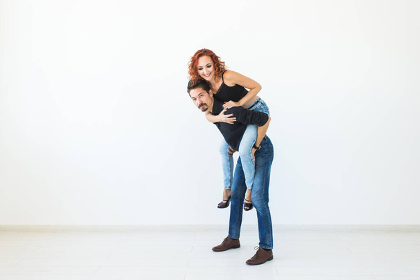 People and love concept - Beautiful pretty woman sitting at man's back and embracing him on white background with copy space - Φωτογραφία, εικόνα