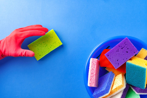 angelehnte Hilfsmittel mit Händen in Gummihandschuhen auf blauem Hintergrund - Foto, Bild