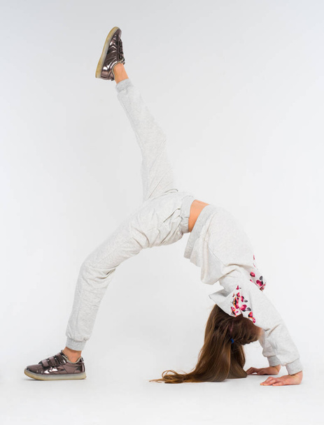 Bambina fare esercizi di ginnastica su sfondo bianco
 - Foto, immagini