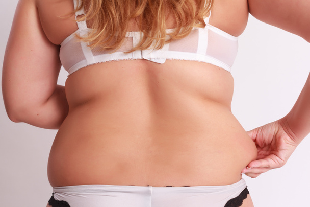 Mujer pellizcos en la grasa en la cintura
 - Foto, imagen