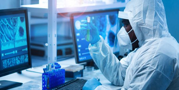 African-american scientist works in a modern scientific lab using laboratory equipment, microscope and computer technology. Invention of new drugs and vaccines. Concept of Science and Health. - Foto, Bild