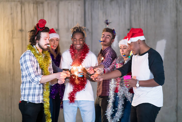grupo multiétnico de pessoas de negócios casuais iluminando um sparkler
 - Foto, Imagem