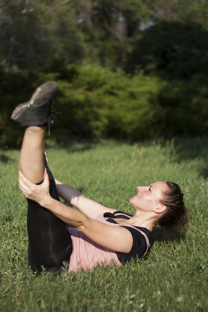 Young woman doing fitness outdoors - 写真・画像