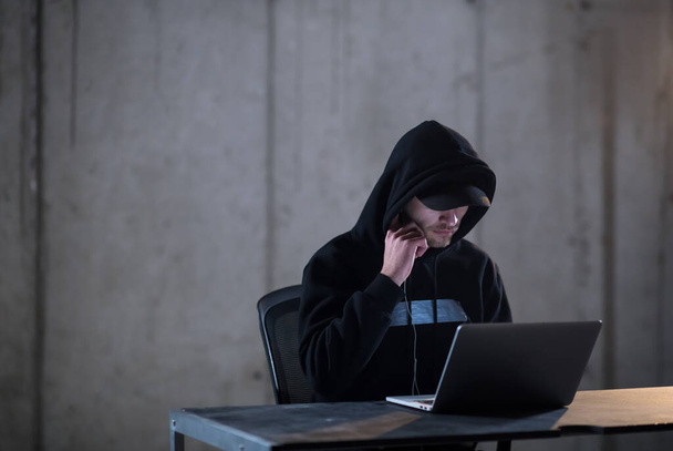 utalentowany haker korzystający z laptopa podczas pracy w ciemnym biurze - Zdjęcie, obraz