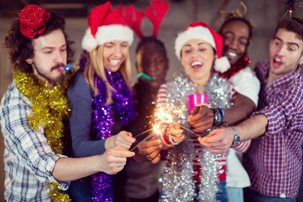 grupo multiétnico de pessoas de negócios casuais iluminando um sparkler
 - Foto, Imagem